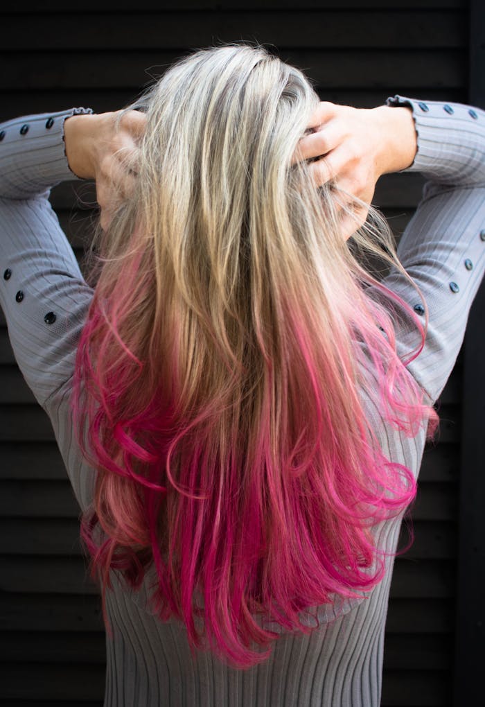 services-01 Close-up of a woman with blonde and pink ombre hair in a stylish pose.